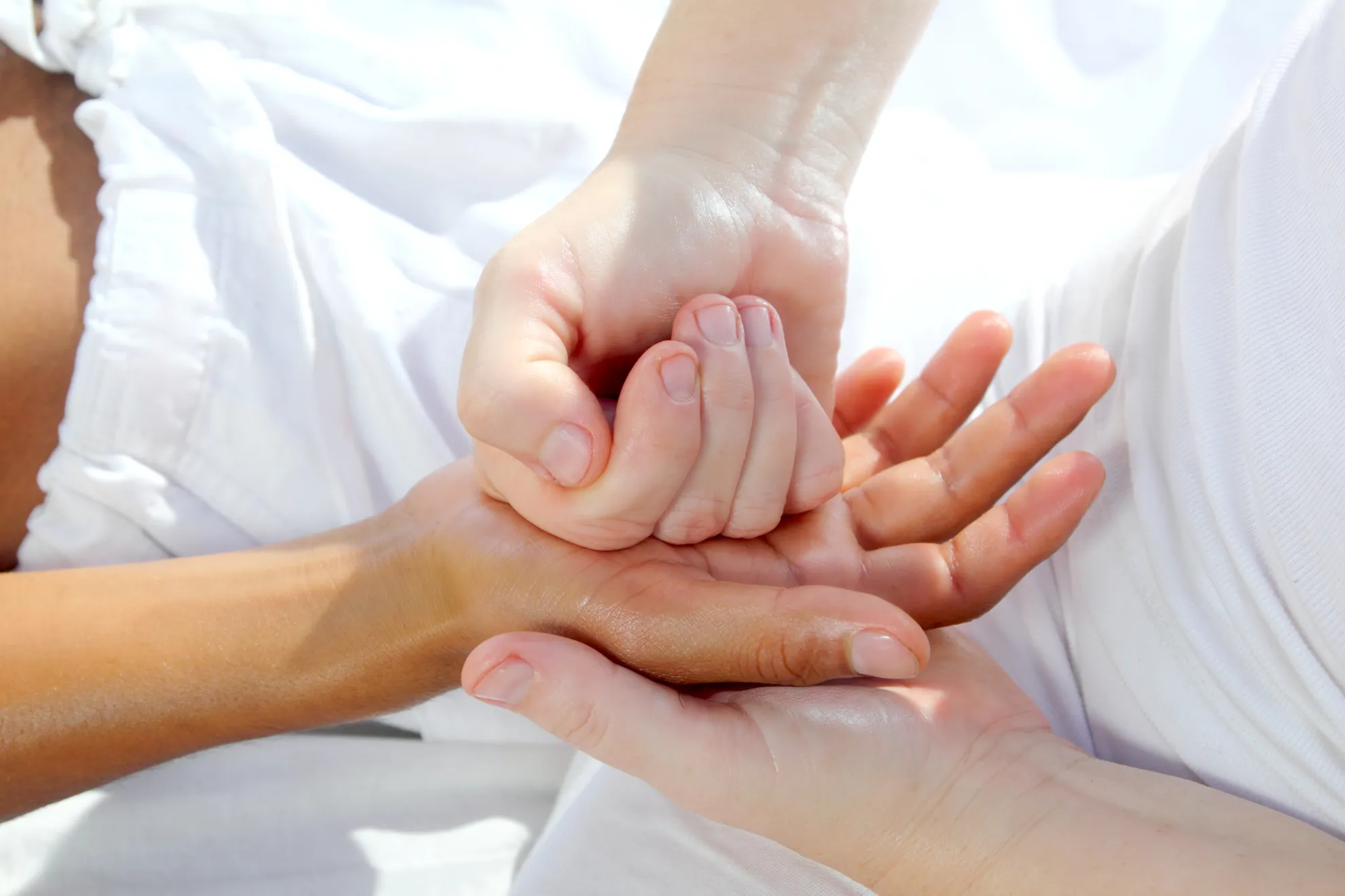 Es wird die Anwendung einer Tuina-Massage-Technik an einer Hand gezeigt